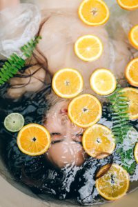 Woman in bath with slices of lemon